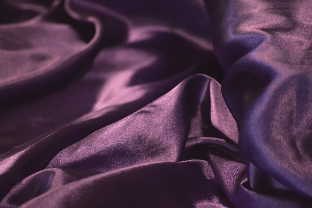 Plis d'un satin violet sous une lumière douce